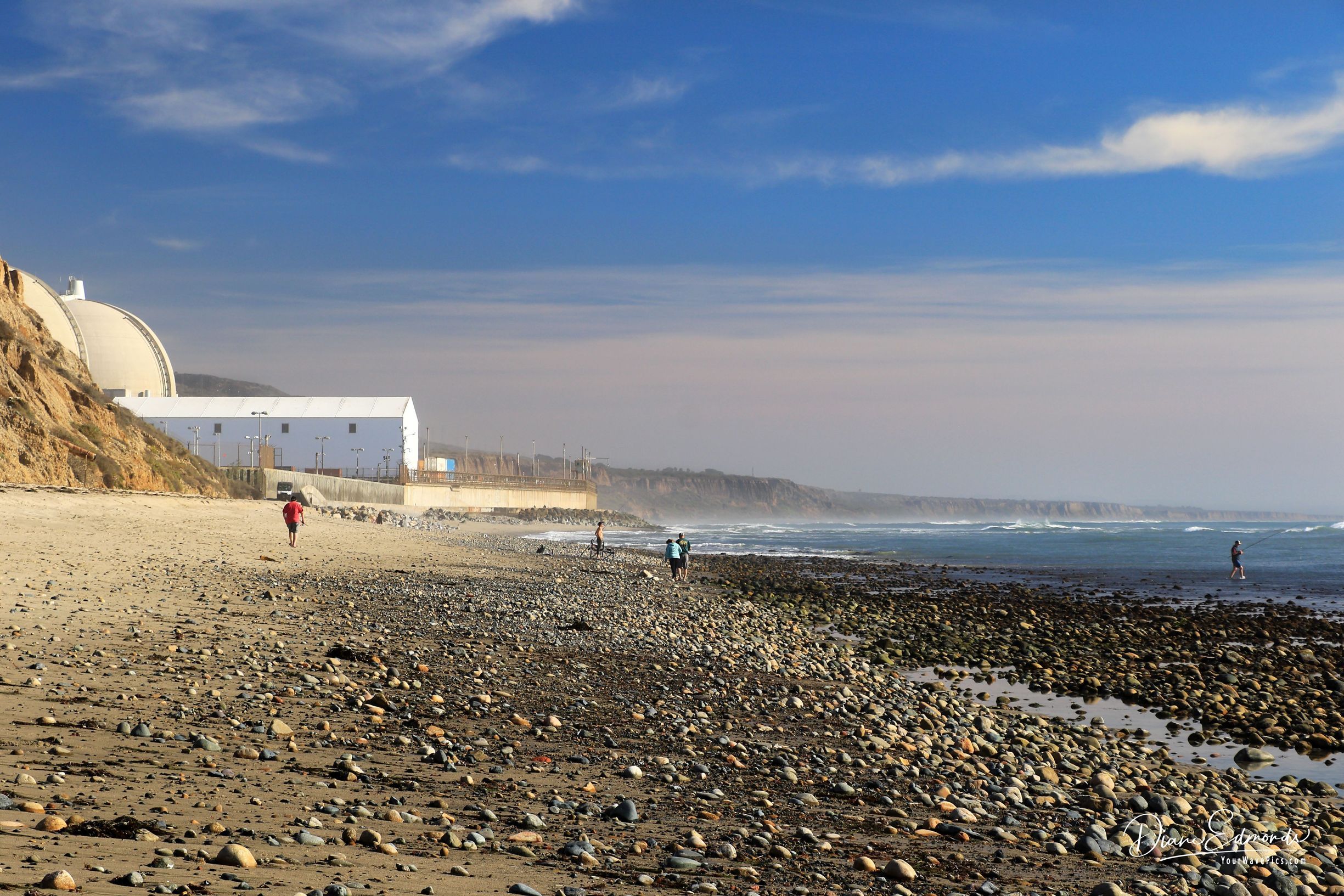 Beachgoers walk alongside SONGS.